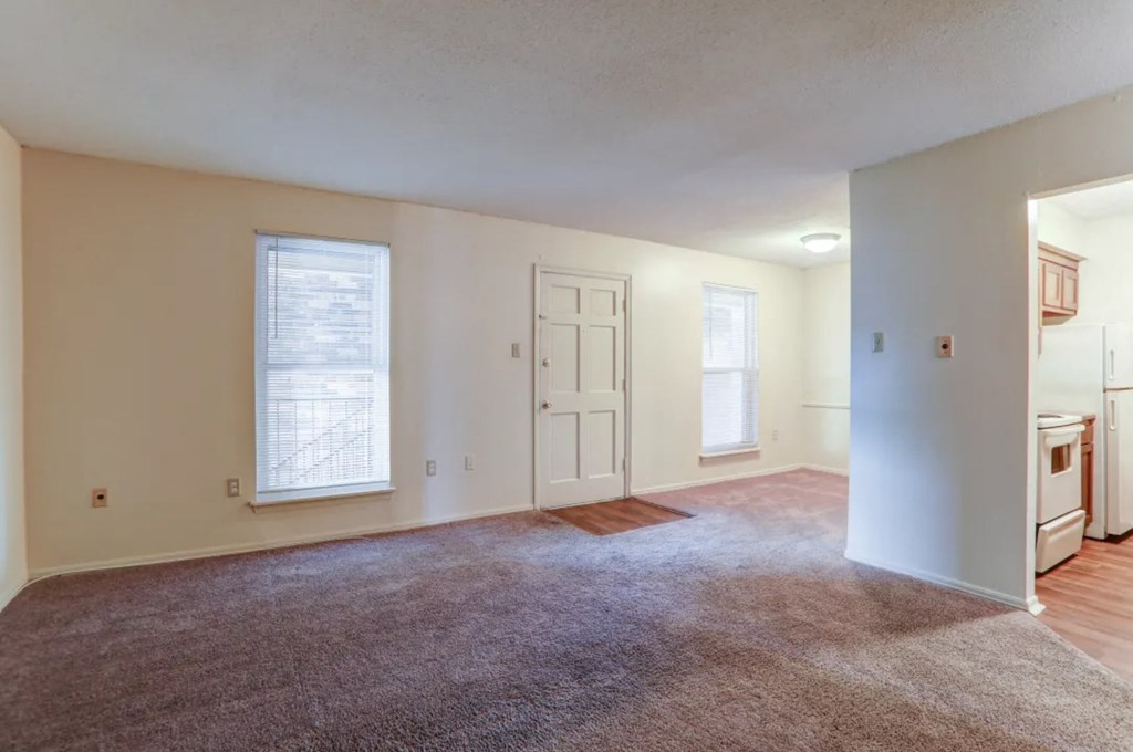 A room with a carpeted floor and a window.